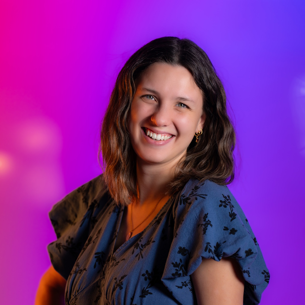 Allison Mays standing, smiling at camera