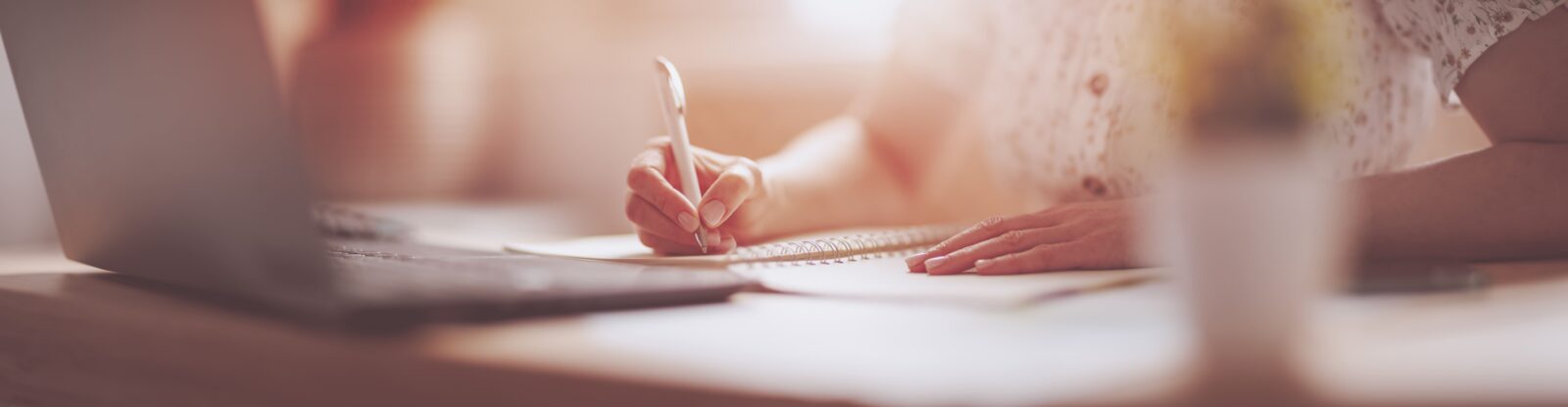 Person writing with a pen in a notebook