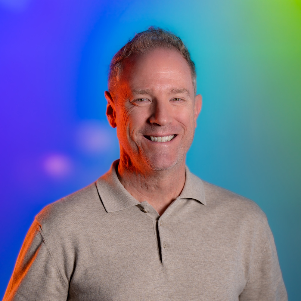 Pete Colbert, standing, smiling at camera