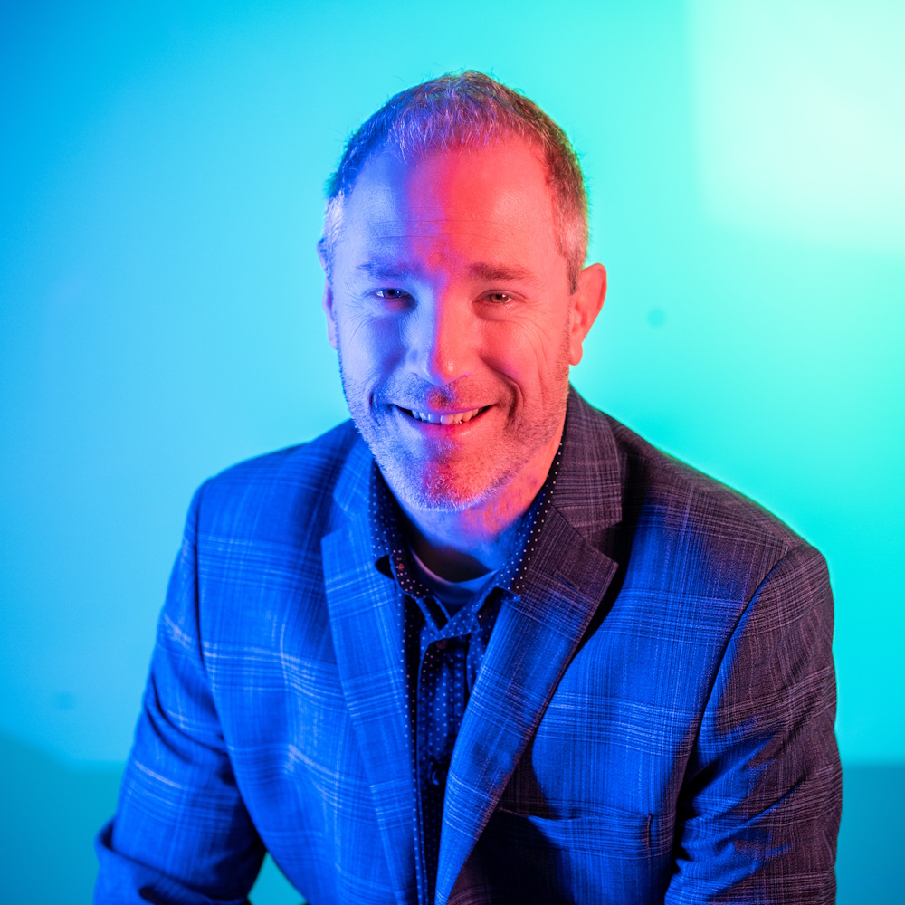 Pete Colbert sitting, facing camera wearing a suit jacket.