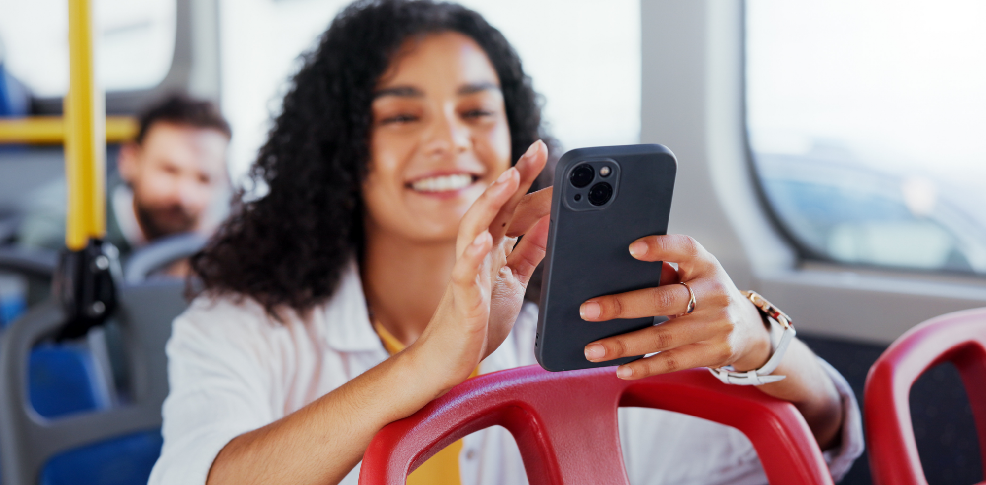 A woman using her smartphone while seated on a bus