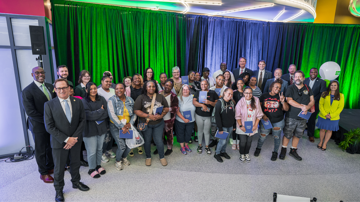 A group of people standing in front of several drapes of different colors