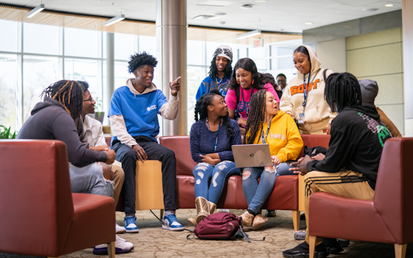 A group of college students seated in a room relaxing.