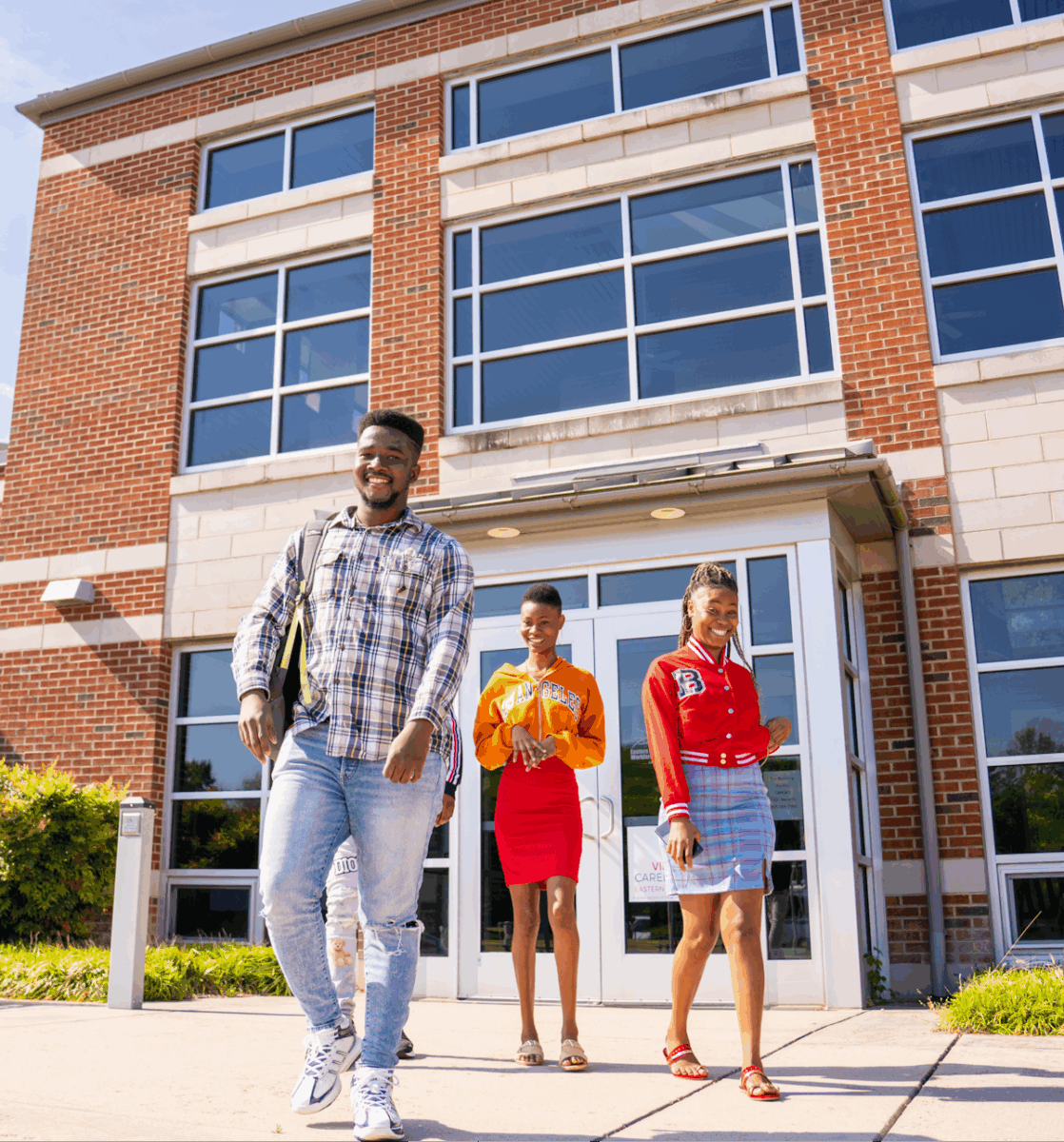 Three people standing outside in front of a building.
