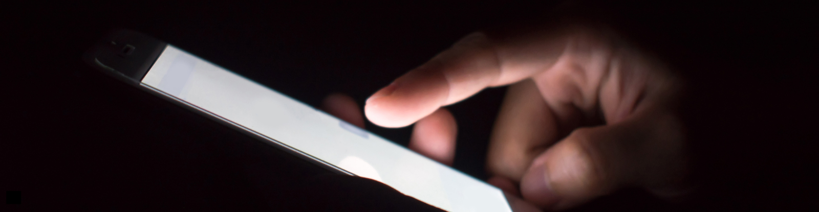 hand holding a phone with lit phone screen