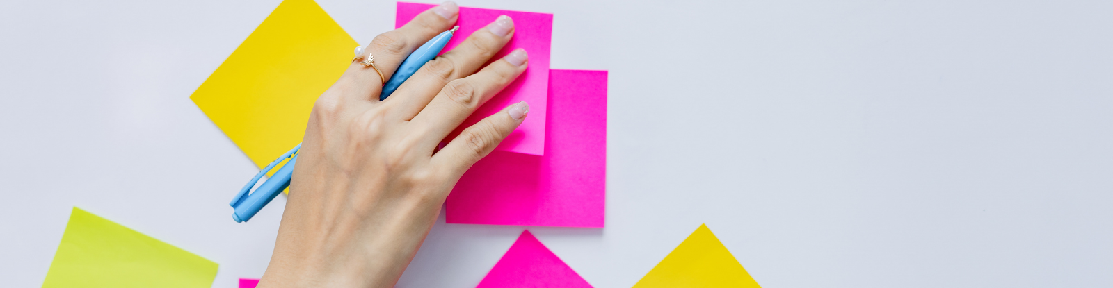 A hand placing post-it notes on a whiteboard.